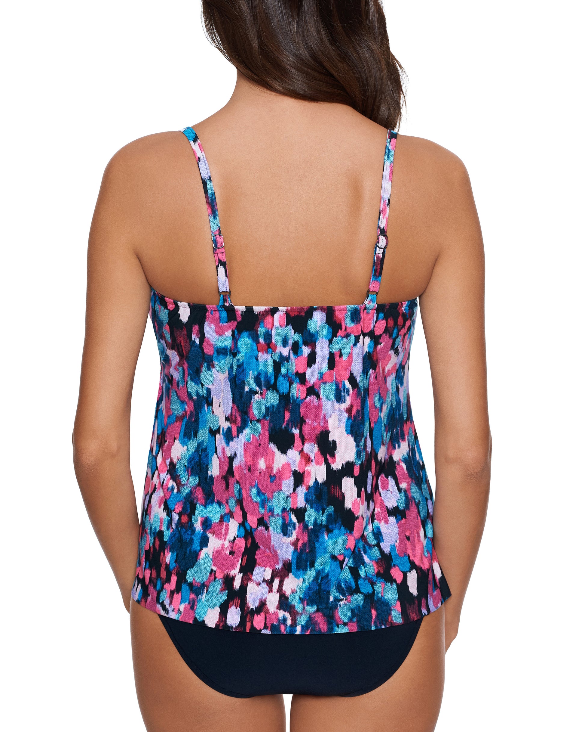 Model wearing a tankini top in a pink, blue, white and black abstract floral print