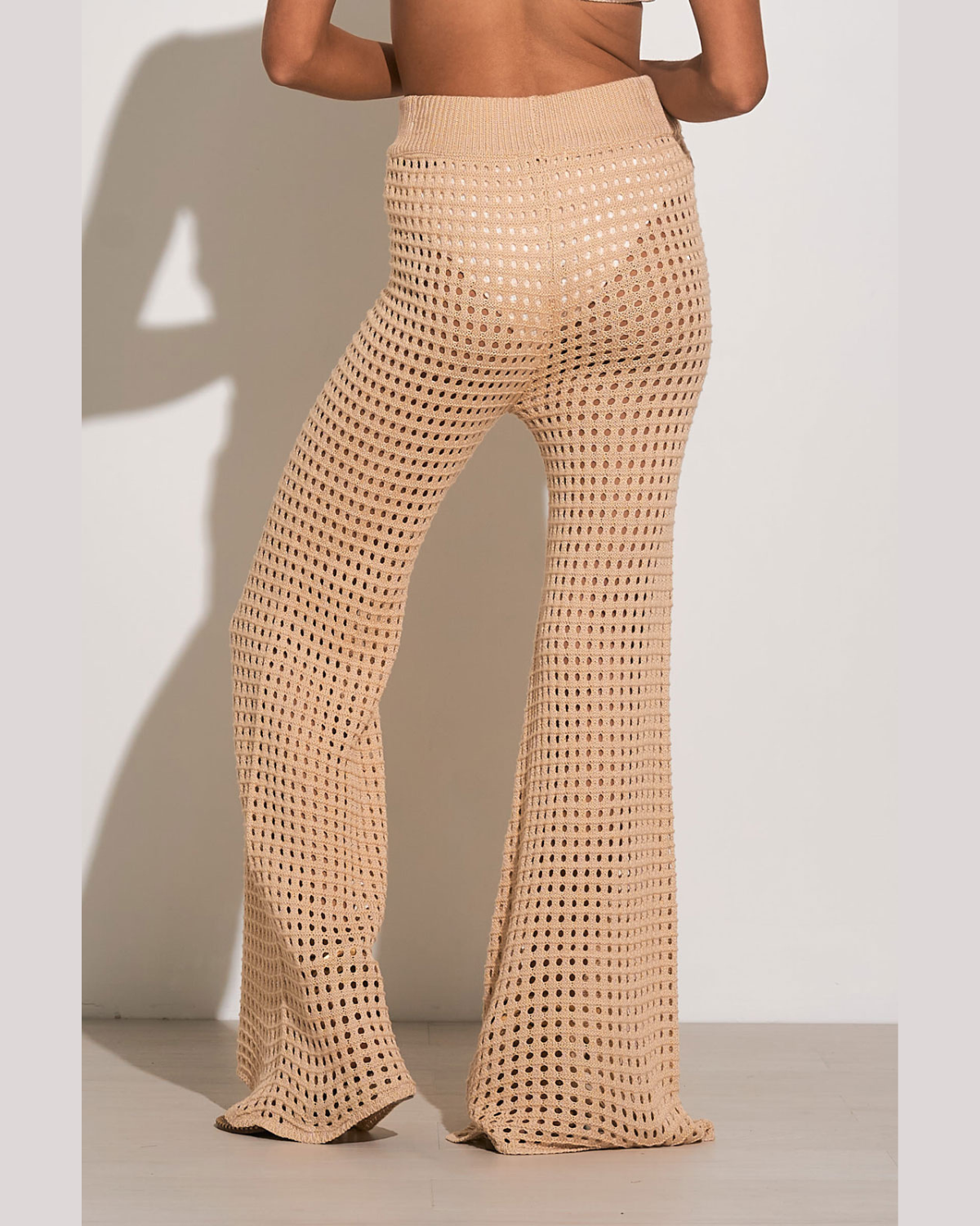 Model wearing a crochet pant cover up in beige