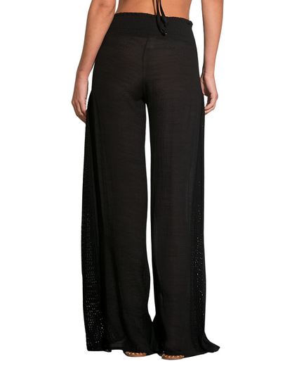 Model wearing a cover up pant with crochet side detail in black