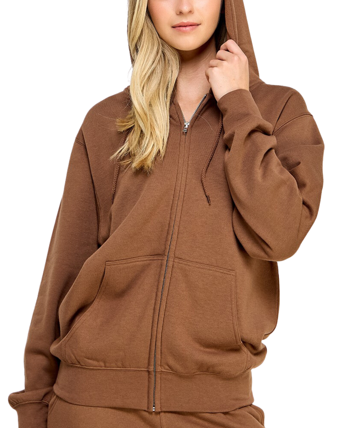 Model on a white backdrop wearing a women's oversized fleece zip up hooded sweater in a solid light brown.