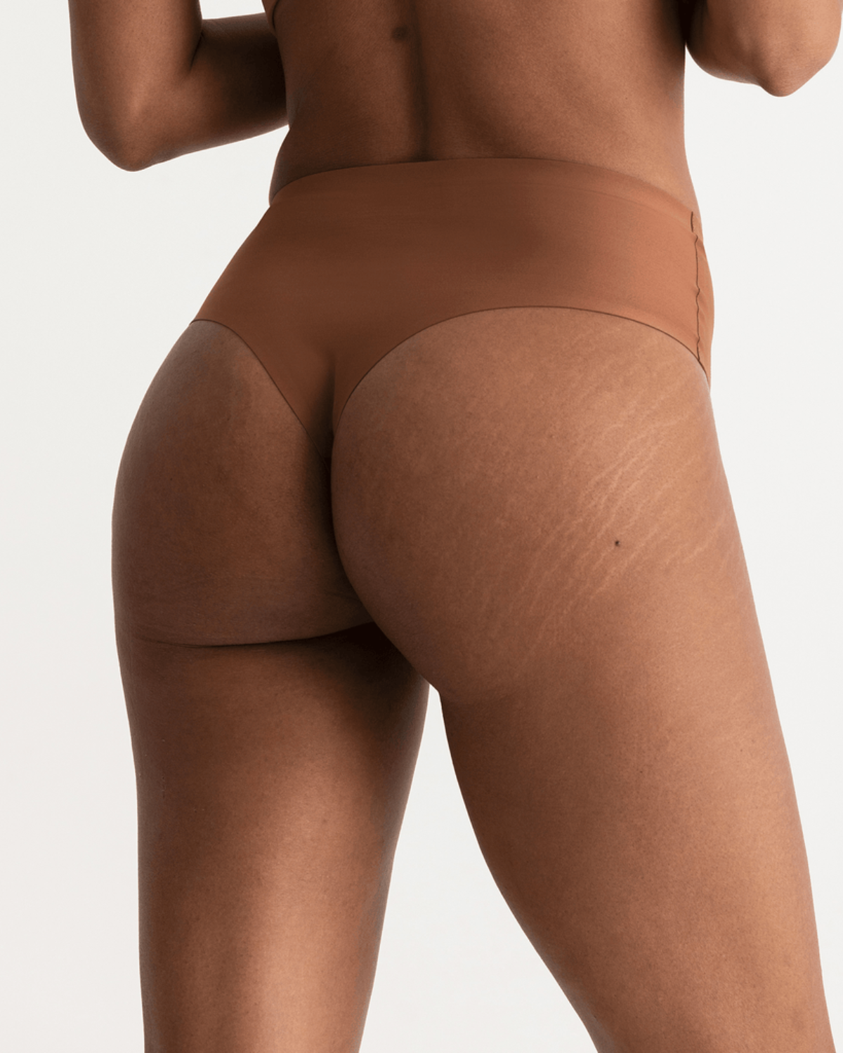 Model wearing a dark nude high waist seamless thong
