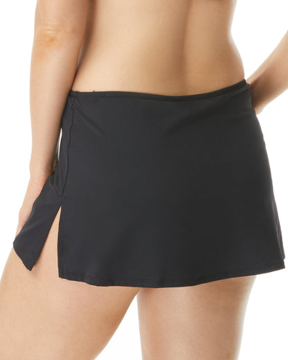Bottom half the backside of a model on white background in a black swim skirt with a slit