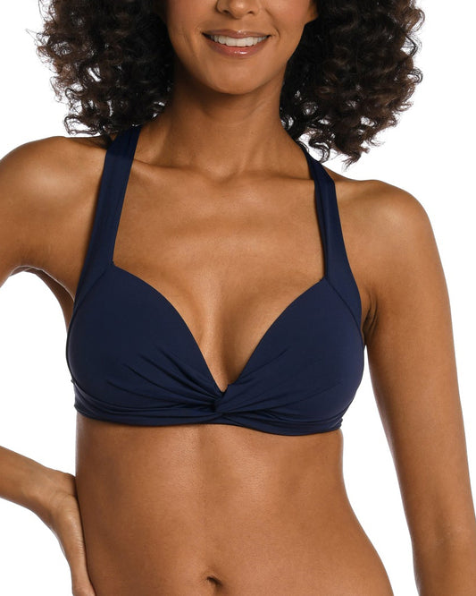 Model wearing a keyhole twist front banded bikini top in indigo