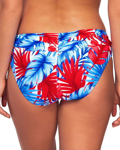 Model wearing a hipster bikini bottom in a red, white and blue palm frond print.