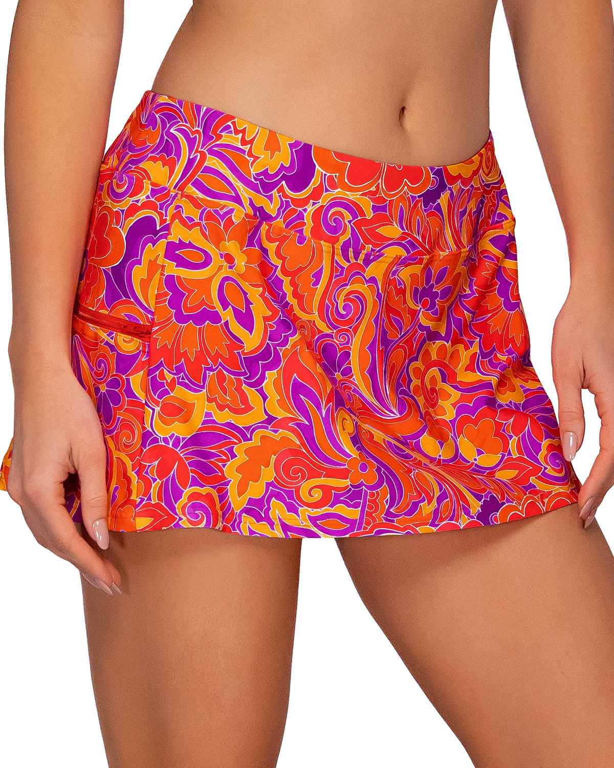 Model wearing a swim skirt with a side pocket and hidden shorts in a red, purple, orange and yellow paisley print