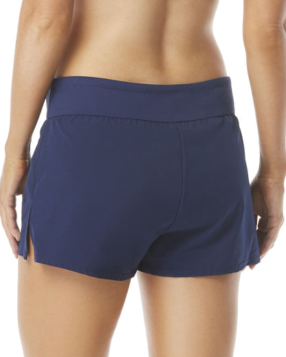 Model wearing a swim short with banded waist and zipper pockets in navy