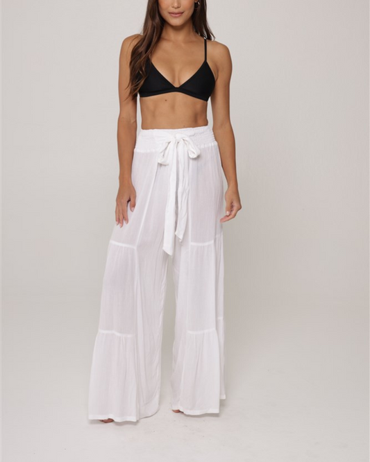 Model wearing a tiered cover up pant with tie belt in white