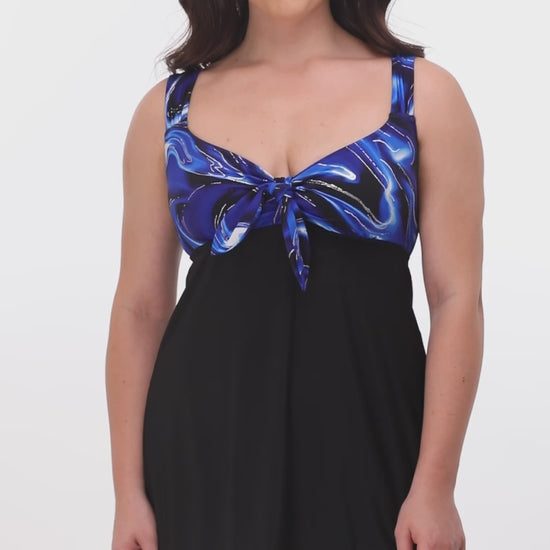 Modeling turning 360 degrees wearing a tie front swim dress in black with a black and blue marble print top