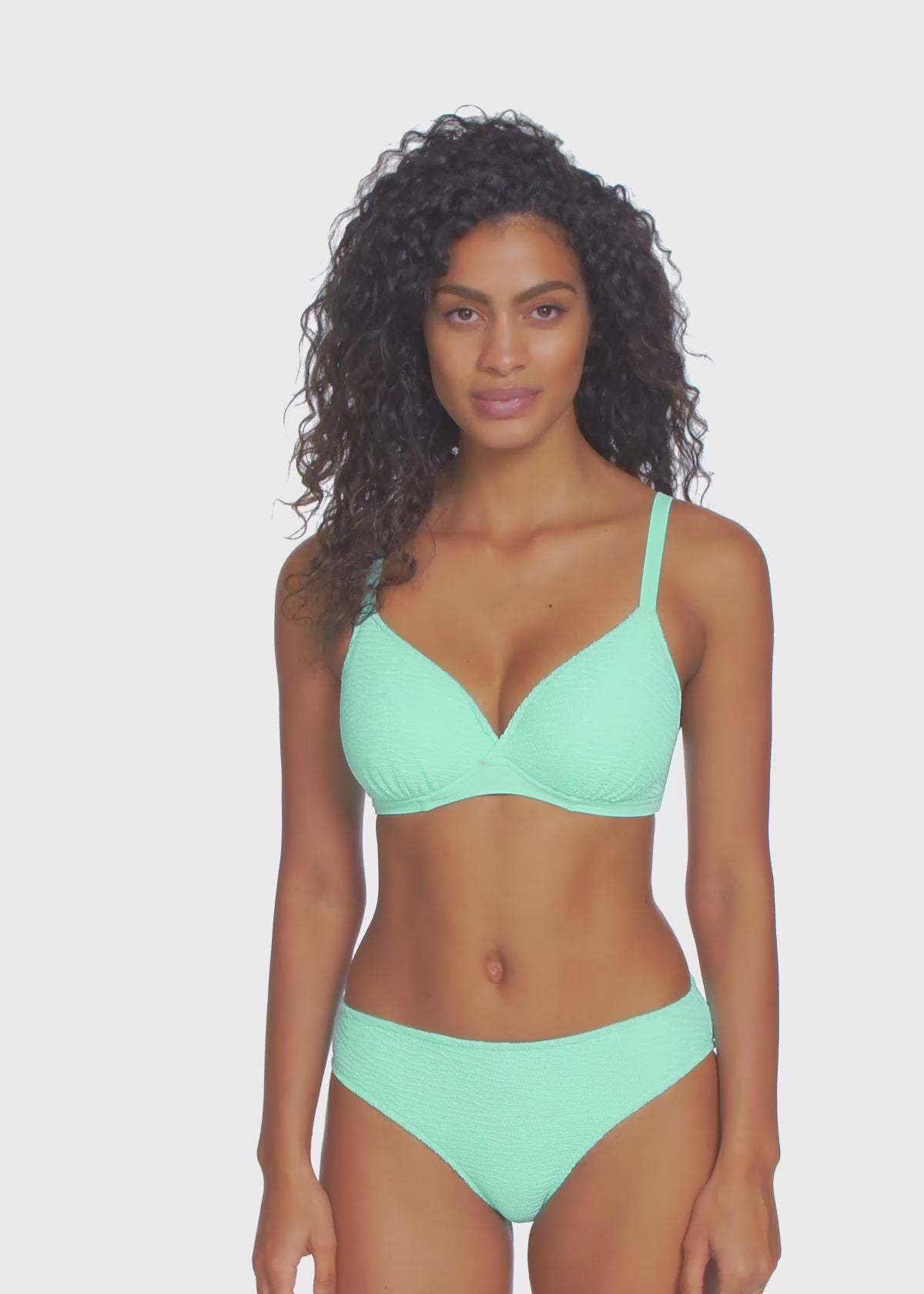 Model turning 360 degrees wearing an underwire plunge bikini top in light turquoise