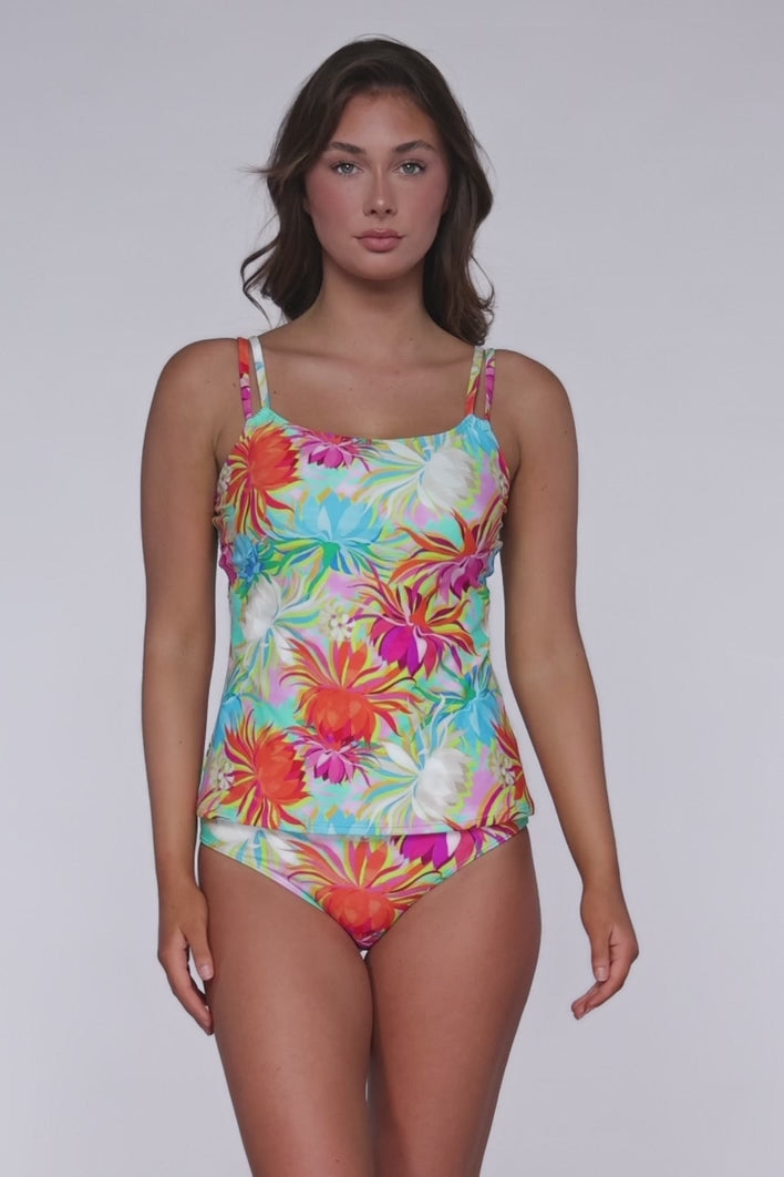 Model rotating 360 degrees wearing a tankini top with hidden underwire in an orange, white. pink, turquoise and yellow floral tropical print.