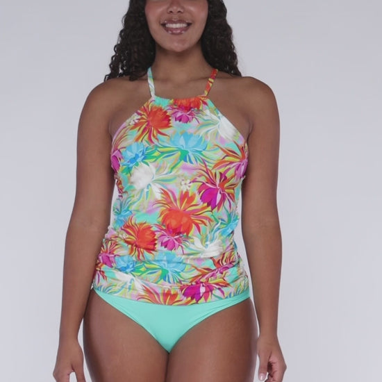 Model rotating 360 degrees wearing a high neck tankini top in an orange, turquoise, white and pink floral print.