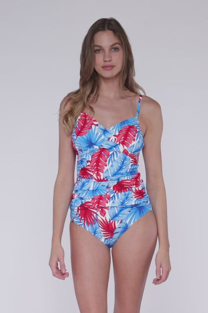 Model rotating 360 degrees wearing a crossover tankini top in a red, white blue palm frond print.