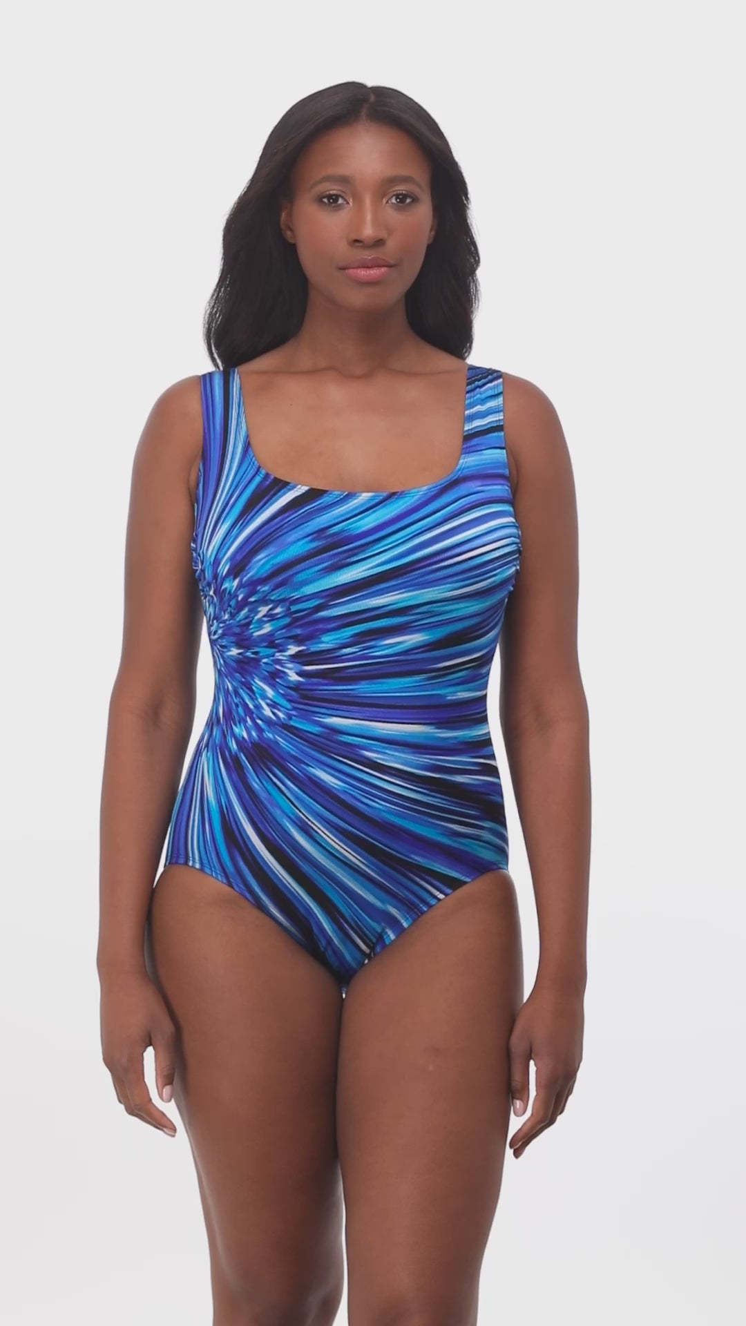 Model turning 360 degrees wearing a scoop back tank one piece in a blue, navy, black and white striped print