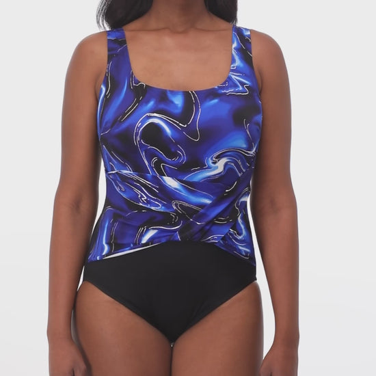 Model rotating 360 degrees wearing a one piece with twist front top in black with a black, blue, white and silver marble print top half.
