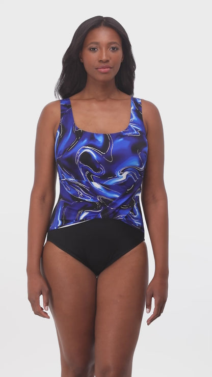 Model rotating 360 degrees wearing a one piece with twist front top in black with a black, blue, white and silver marble print top half.