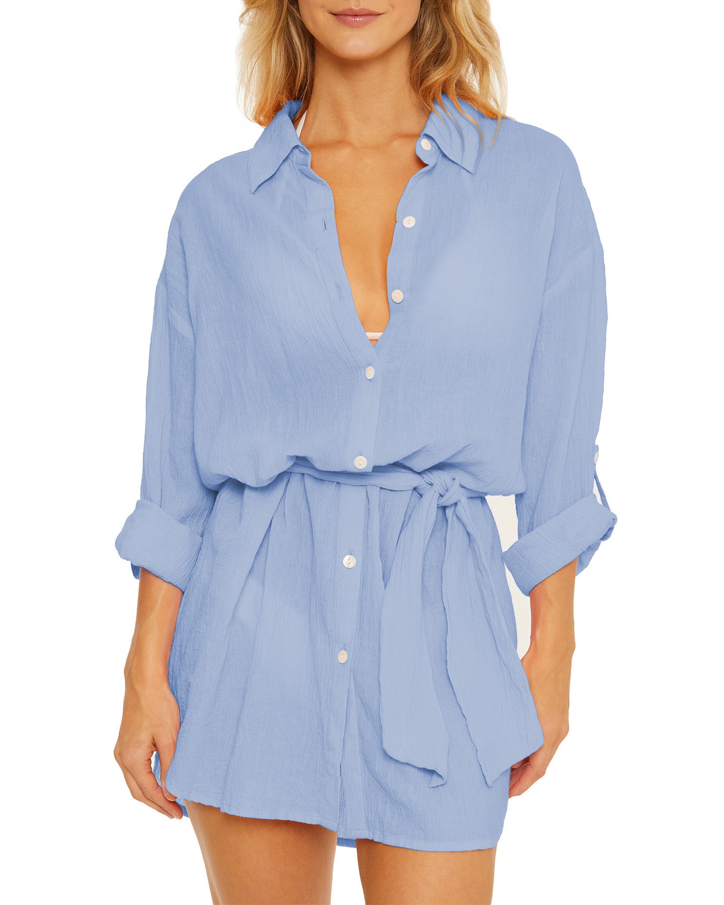 Model wearing a gauzy button up shirt dress in light blue