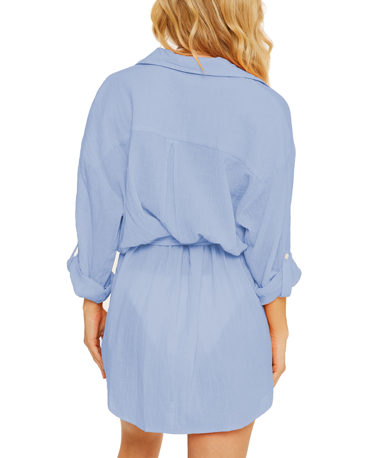 Model wearing a gauzy button up shirt dress in light blue