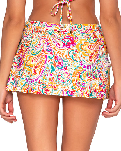 Model wearing a swim skirt with side pocket and hidden short in a white, yellow, red, purple and turquoise paisley print.