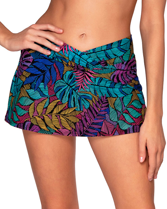 Model wearing a v front swim skirt in a pink, purple, blue and yellow palm frond print.